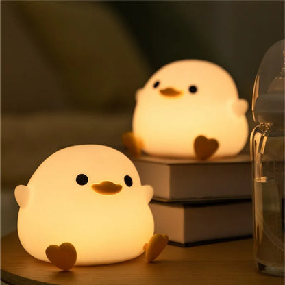 Two duck night lights presented in a room, illuminating it's presence.